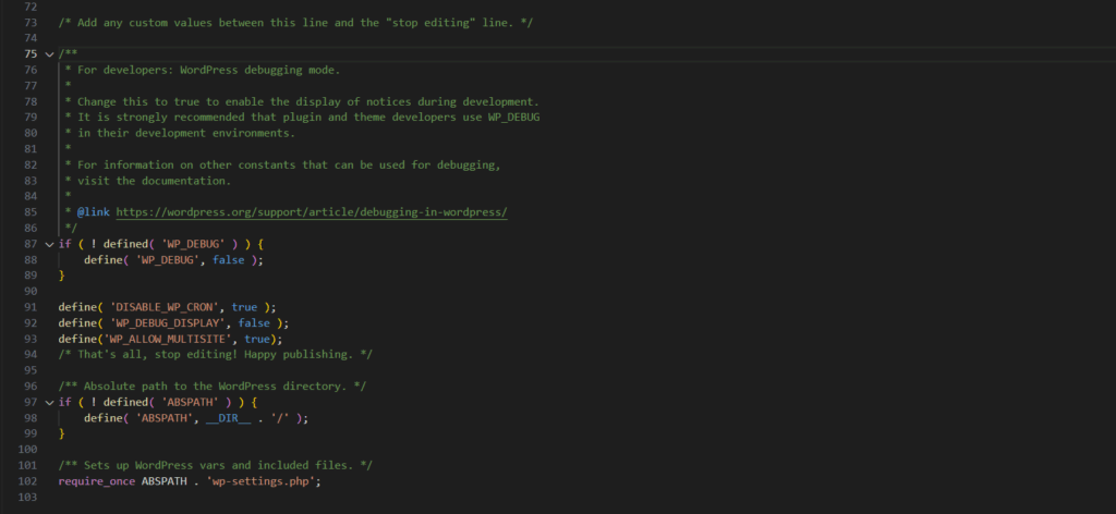 Screenshot eines Code-Editors mit einem Ausschnitt aus der wp-config.php (Zeilen 75–103): Zuerst ein Kommentarblock zur WordPress-Debugging-Dokumentation, danach PHP-Definitionen für WP_DEBUG (false), DISABLE_WP_CRON (true), WP_DEBUG_DISPLAY (false) und WP_ALLOW_MULTISITE (true), anschließend der Hinweis „That’s all, stop editing! Happy publishing.“, gefolgt von der Definition von ABSPATH (__DIR__ . '/') und dem require_once ABSPATH . 'wp-settings.php'.